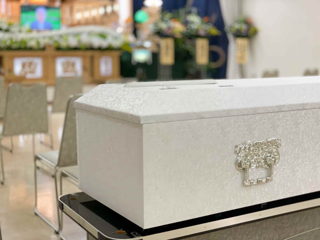葬儀場で白い棺が置かれている様子