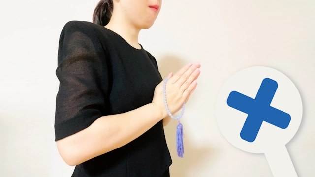 お葬式でNG服装の事例として女性が肘が出て透け感のある半袖のワンピースを着てお葬式に参列している